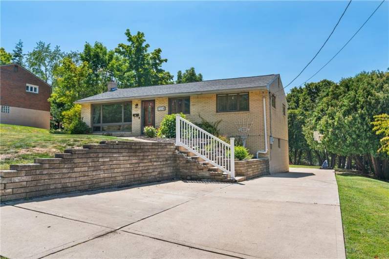 Large low maintenance driveway with plenty of room parking cars.  Versa lock retaining wall and vinyl railing on concrete steps. Wall in front of railing for steps is decorative.