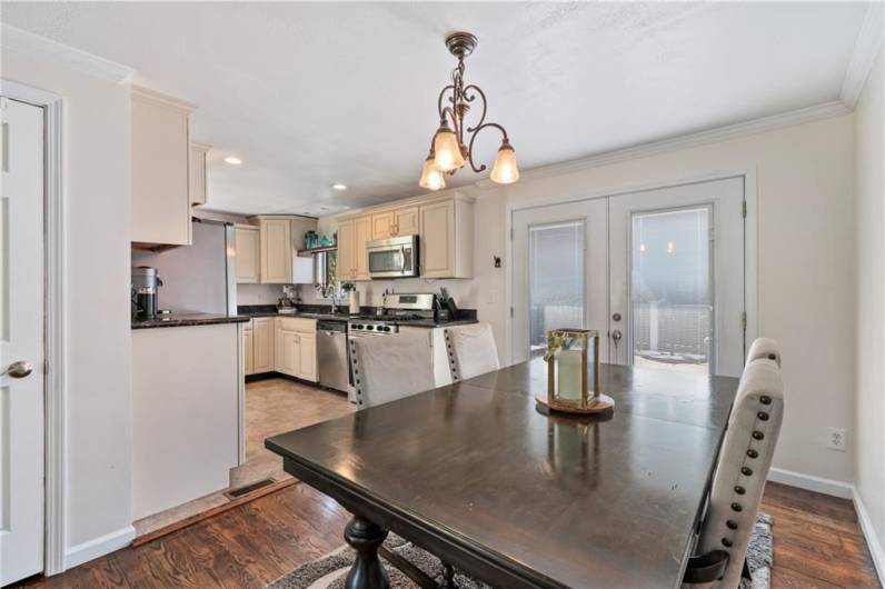 Dining area is open from living room and features pantry and French doors with built in blinds for easy access to oversized deck.