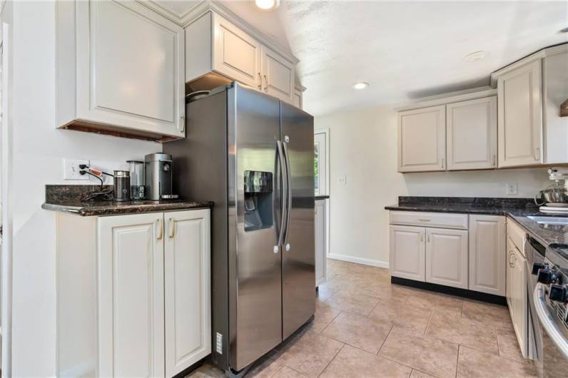 Stainless appliances with gas stove, over the range microwave, dishwasher and refrigerator with water and ice dispenser and granite countertops.