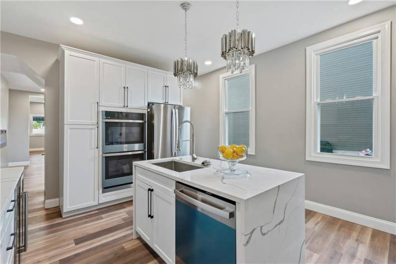 Spacious kitchen with abundant natural light and elegant lighting fixturesc