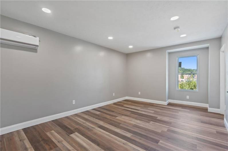 Spacious bedroom with recessed lighting and ample storage space.