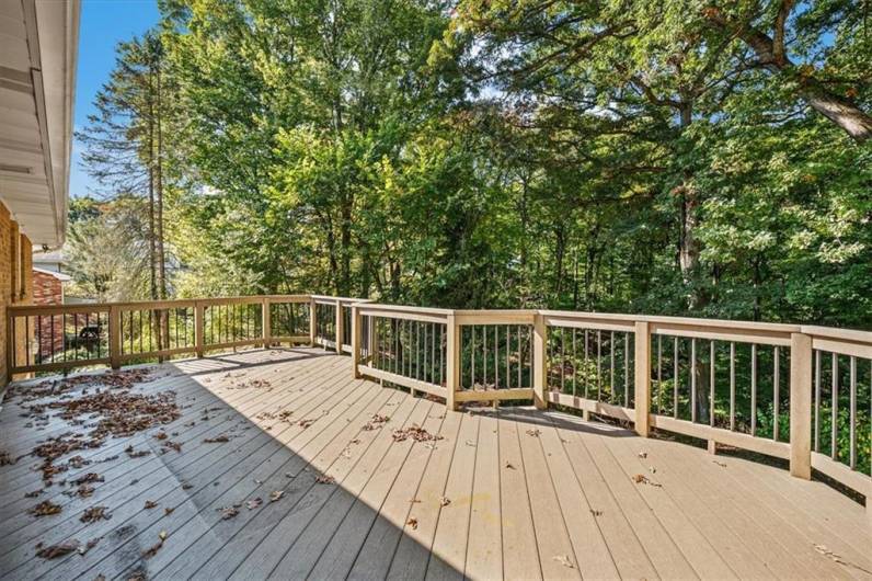 The large deck overlooks the wooded backyard