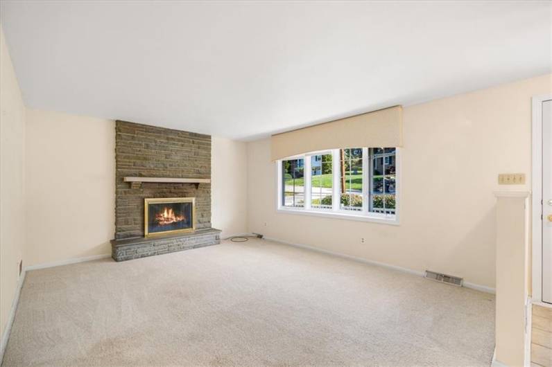 The living room offers a beautiful woodburning stone fireplace