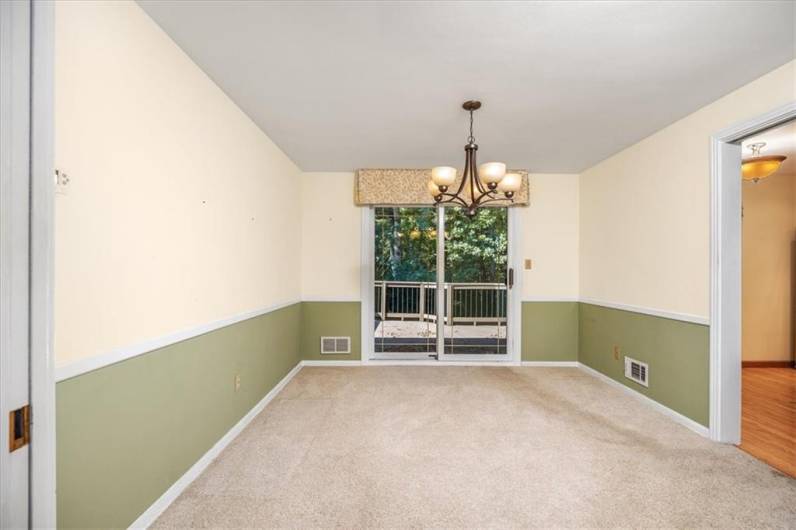 The spacious dining room is adjacent to the kitchen and has a patio door to the deck