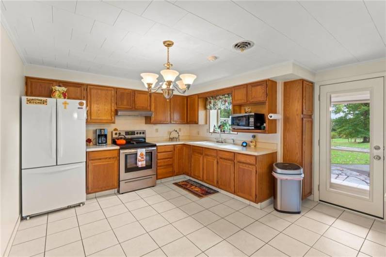 Lower Level 14x13 Eat-in Kitchen with Ceramic Tile Floors, Plenty of Wood Cabinets, Attractive Chandelier, All Appliances & Door to 21x6 Covered Back Porch. Ideal In Law Suite