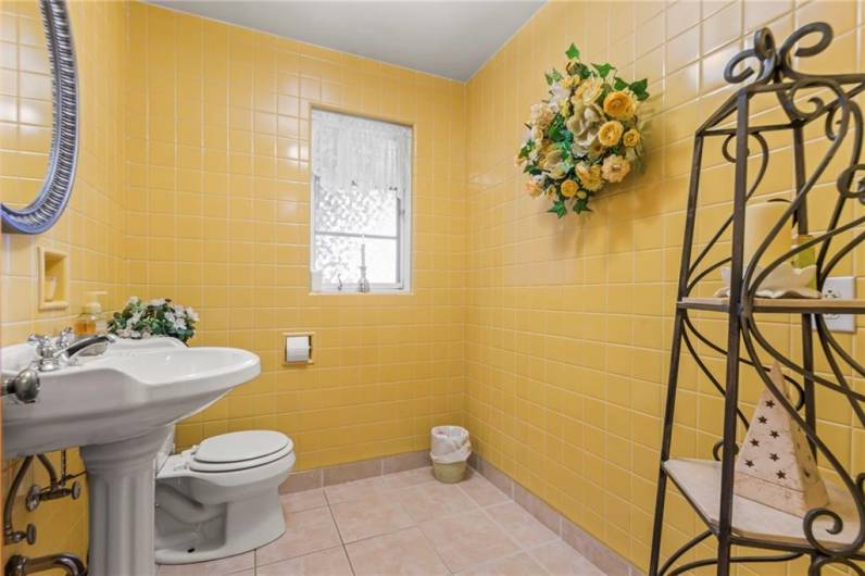 Generous Sized 1st Floor Powder Room highlighted w/ Vintage Ceramic Tiled Walls & Attractive Ceramic Tile Flooring expanding to include baseboard trim