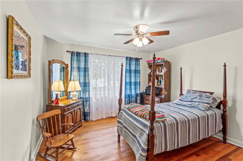 Beautiful Wood Floors in 12x10 Bedroom on main level offering a Ceiling Fan Light & continuing with the Oversized Windows calling in Nature's Beauty plus nice sized closet w/ light