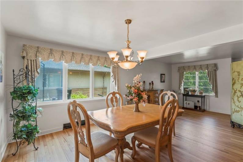 Separate Formal 14x12 Dining Room boasting Original Refinished Hardwood Floors, Attractive Chandelier & Wall of Windows calling in the Natural Light!