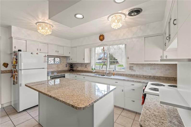 Stunning 14x12 Eat-in Kitchen featuring Gorgeous Granite Counter Tops, Breakfast Bar Island, Attractive Glass Block Windows, Plenty of Cabinets, Beautiful White Brick Backsplash, Deep Double Stainless-Steel Sink, All Appliances & Elegant Crystal Chandelier Light Fixtures in addition to recessed lighting!