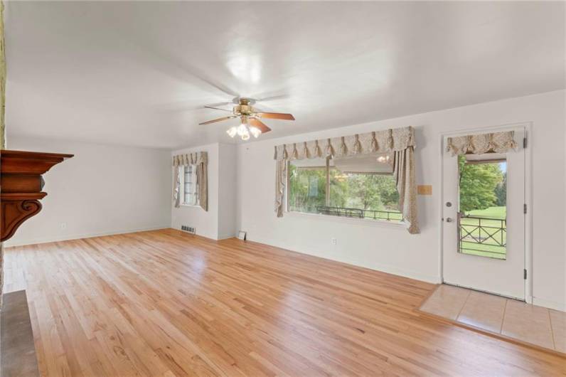 LARGE 29x16 Living Room w/ Refinished Original Hardwood Floors, Ceiling Fan Light, Big Picture Window & Door to 21x6 Covered Porch offering convenient Ceramic Tile Entryway