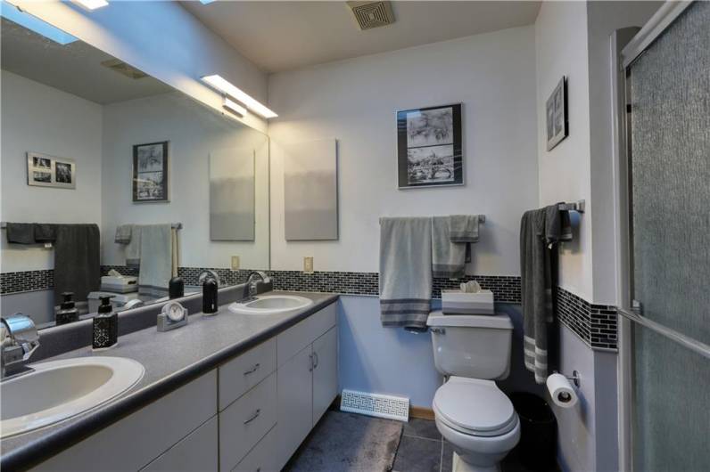 Notice the double sinks for added convenience and the walk-in shower unit. This ensuite bath also features a skylight.