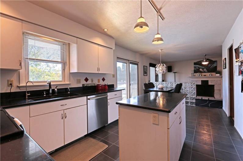 The black quartz countertops are a more recent addition to the kitchen, as well as the flooring and stainless steel refrigerator.