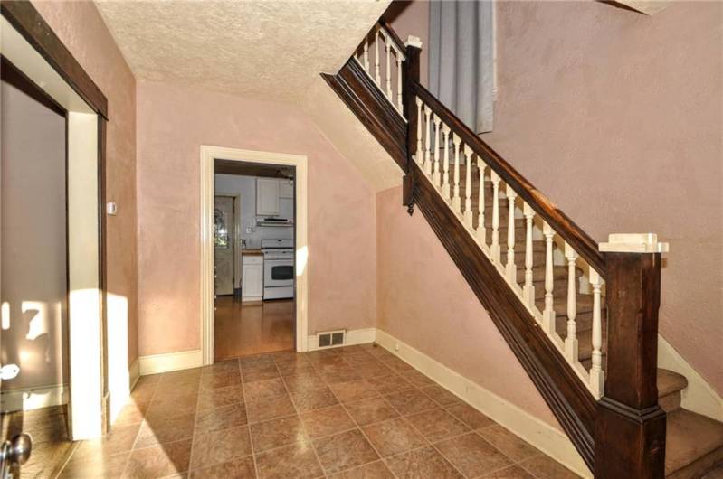 Your spacious entryway showing the kitchen straight ahead, living room off to the left and the stairs leading to the 3 bedrooms and full bath