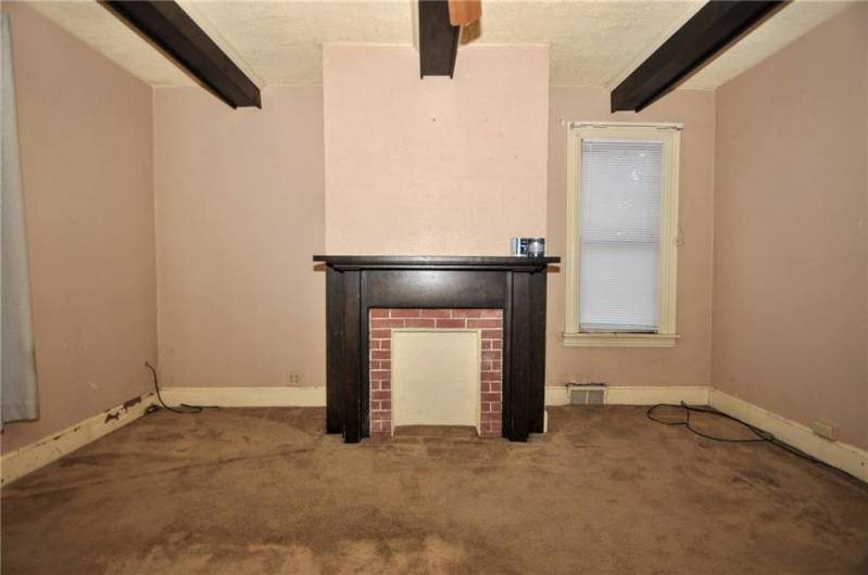 The spacious living room with the decorative fireplace