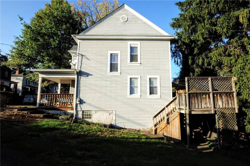 This side view shows the front covered porch as well as the huge back deck