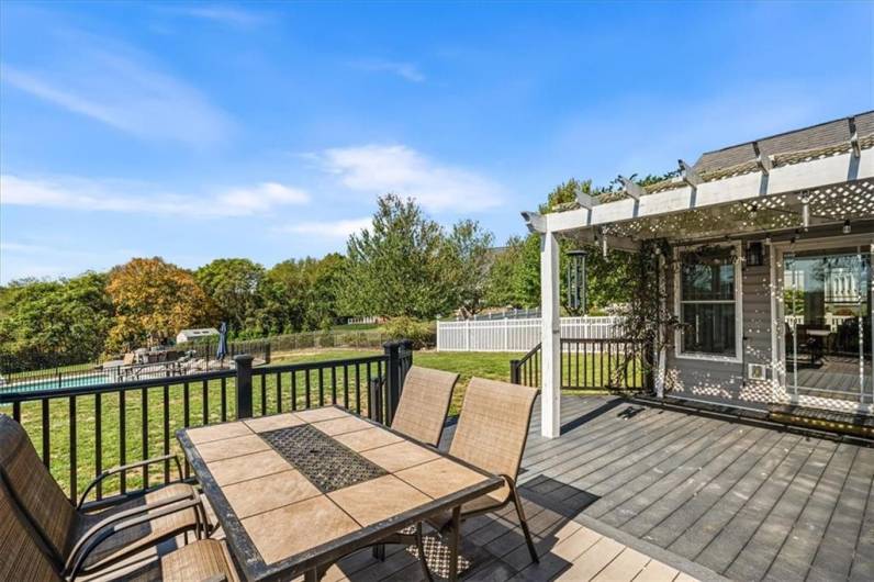 Deck overlooks large back yard and pool area