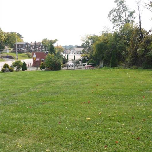 VIEW OF LARGE VACANT LOT NEXT TO BUILDING AND PARKING LOT