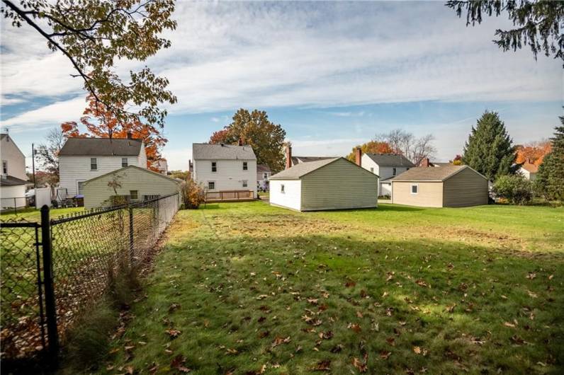 Large back yard view to garage and house