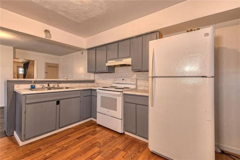 The kitchen in 116 has grey painted cabinetry and white appliances.