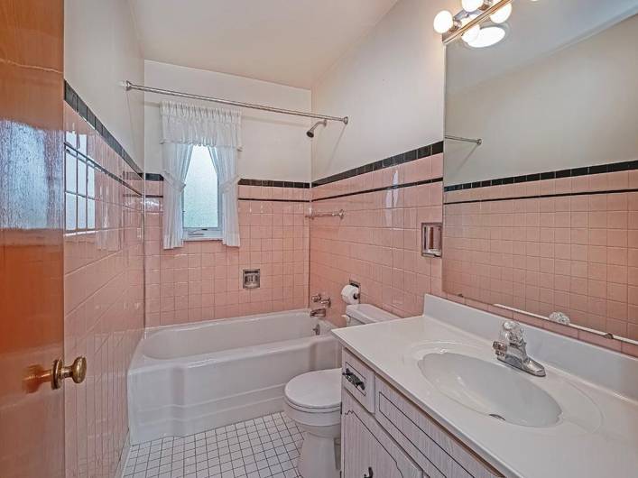 Main floor bathroom has ceramic tile floors and walls.