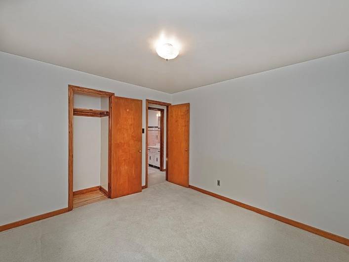 View of entry into the primary bedroom, closet and hallway bathroom view.