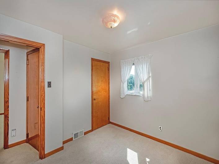 View of bedroom 2 not virtually staged. Hardwood under the carpet.