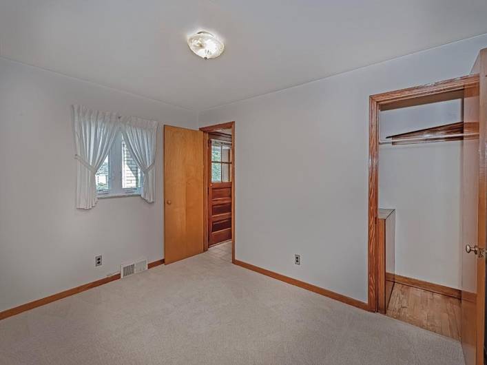 View of bedroom 3 and door leads in the kitchen. The other door leads to covered back deck.