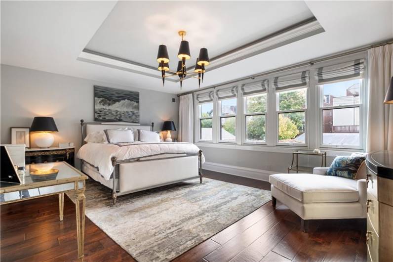 Tri-layered ceiling with chandelier, and large beautiful windows.