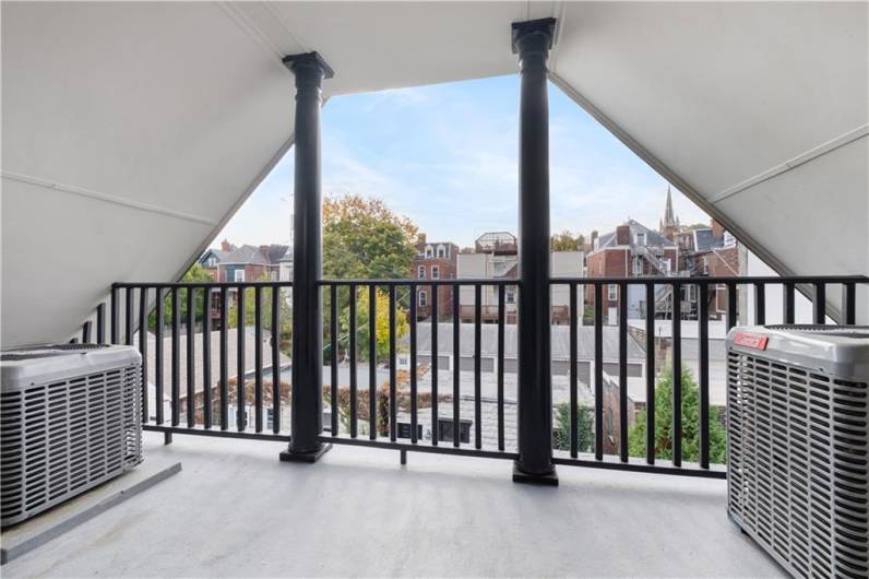 Third floor outdoor covered balcony overlooking private patio.