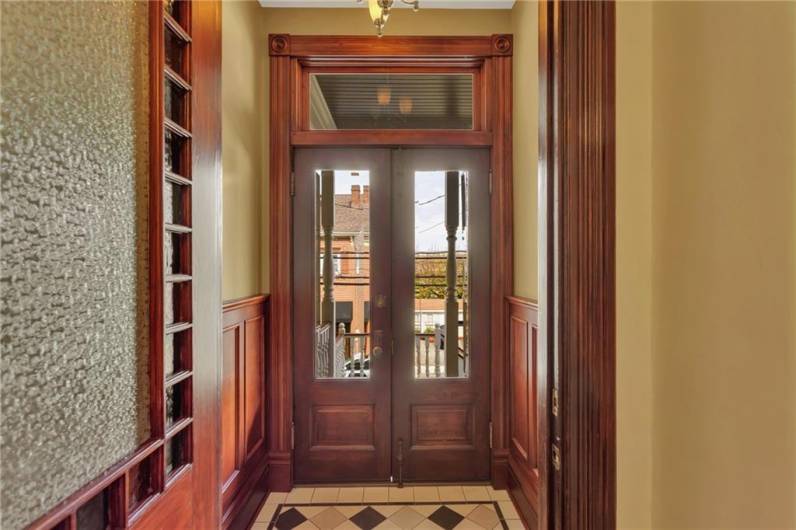 Double entry vestibule with transom and leaded glass.