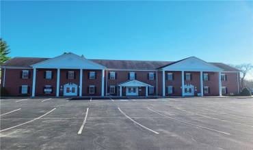 Front view of this brick building showing some of parking lot spaces