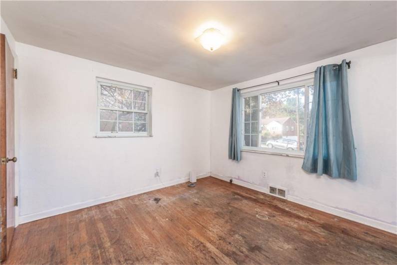 The dining room with another large window for natural light and the hardwoods that need some love.