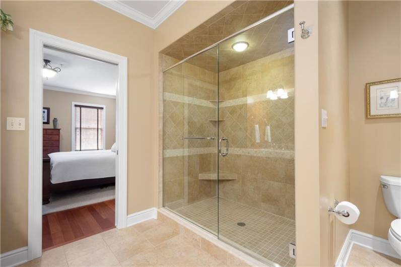 Colossal walk-in shower in a primary bathroom that’s so bright, it practically sparkles! And let’s not forget those fantastic moldings that add that extra pop of luxury.