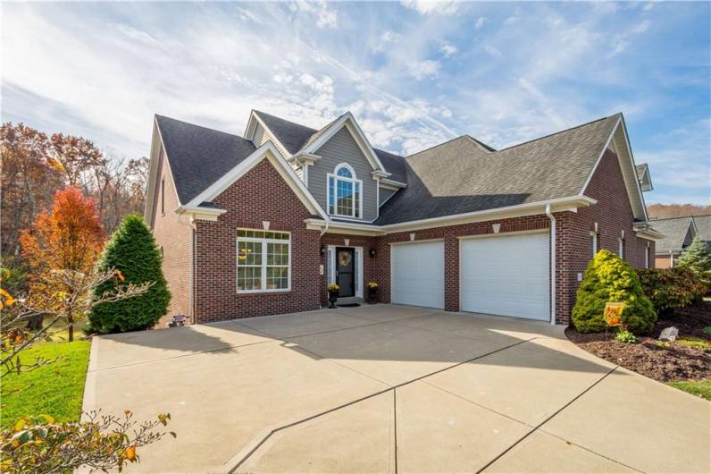 A two-car garage featuring an attached design and a cement driveway.