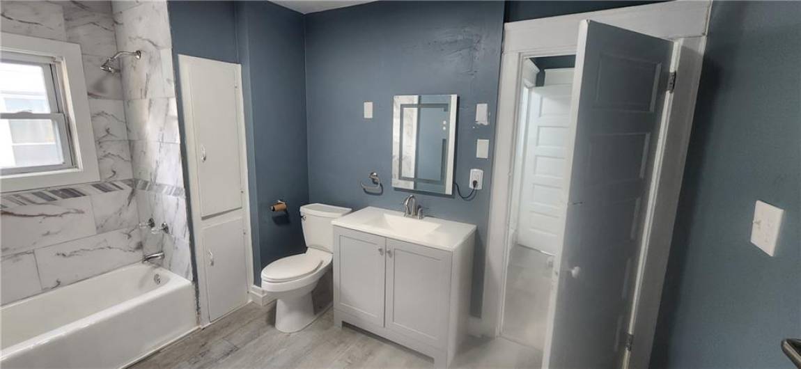 Updated bathroom with tub/shower combo, new vanity & mirror