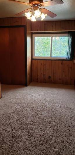 One of the spacious bedrooms with carpeting & Ceiling fan