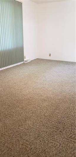 Spacious living room with carpeting.