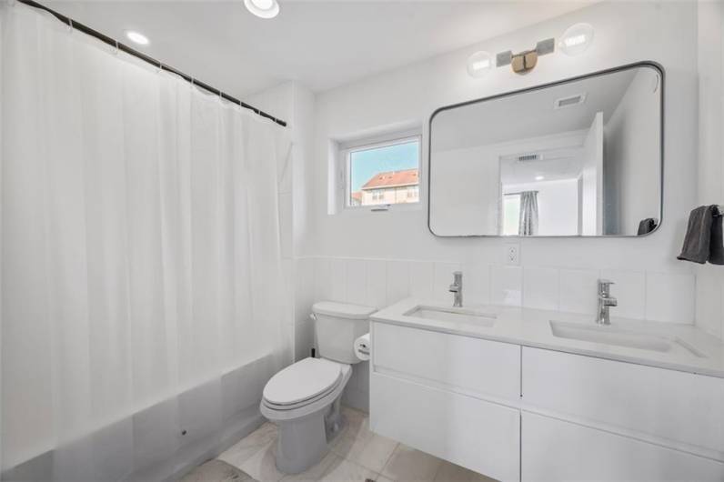 Honed Eastern white marble in master bath, Moen bath fixtures, and deep soaking bathtub.