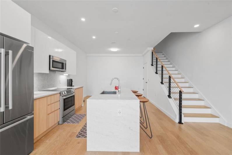 White lacquer kitchen cabinets, Bosch stainless steel appliances, with honed Italian carrera marble countertop.