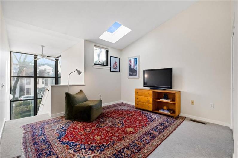 The 2nd bedroom has a gorgeous skylight view and overlooks the floor to ceiling windows ascending from the 1st to 2nd floors.