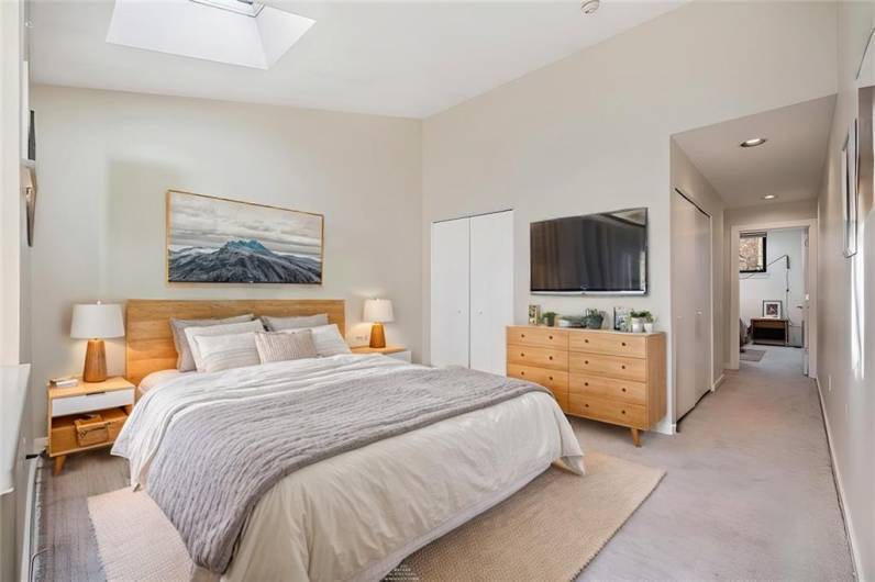 Virtually staged second bedroom with plenty of space for bedside tables and clothing storage. Note closets at rear.