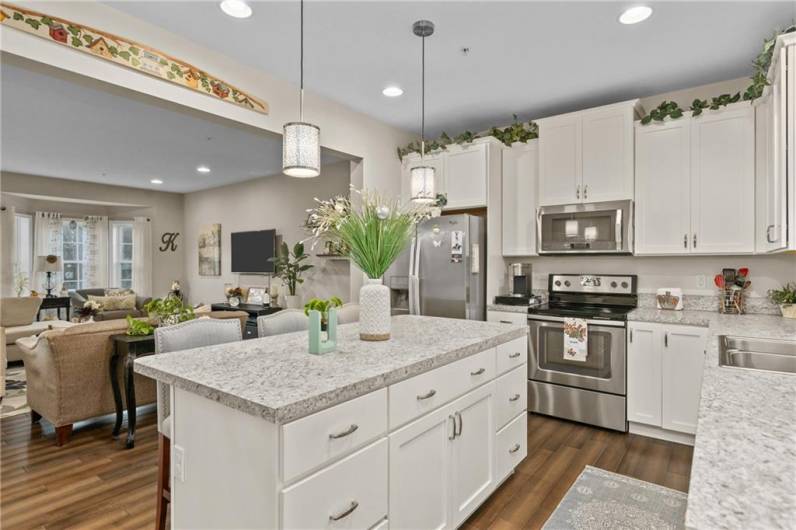 Open Concept kitchen with island open to the dining area, dining room area, and living/family room space.