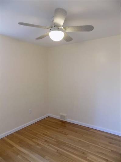 3rd bedroom features ceiling fan and gleaming hardwood floors.