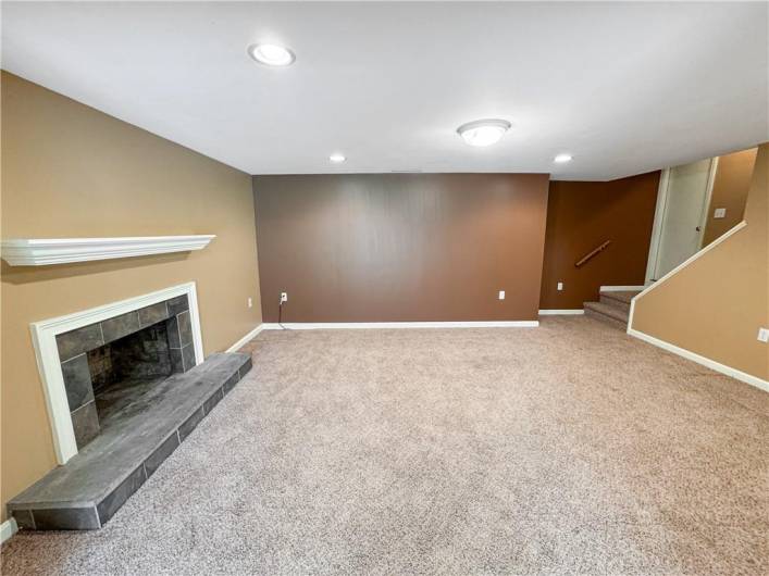 Spacious family room with recessed lighting and a fireplace.