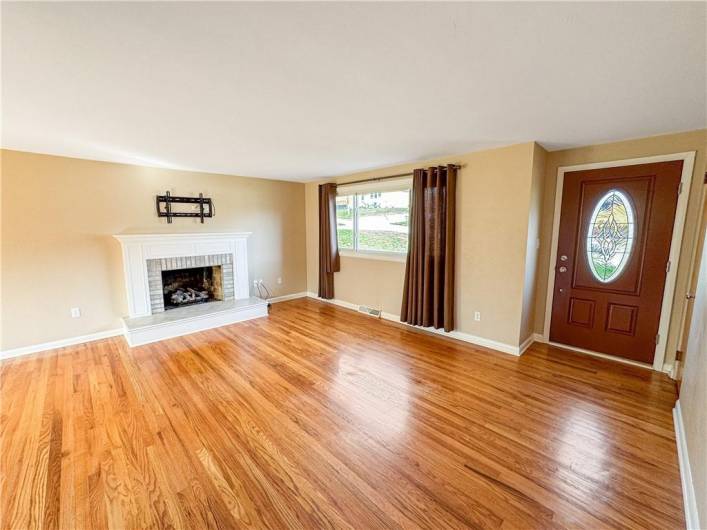 Gleaming hardwood floors and fireplace in the living room.