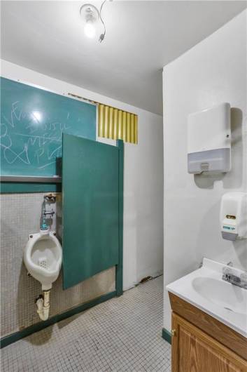 Men's Room with urinal, vanity, and toilet stall.