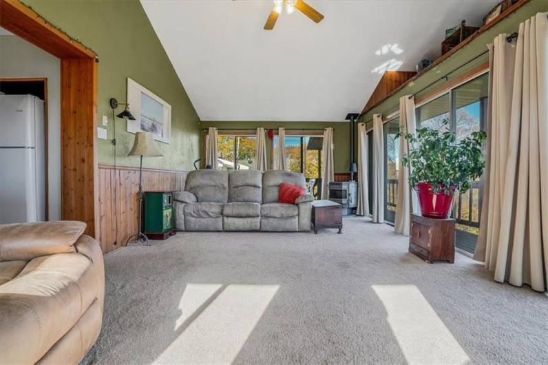 Spacious seating area in the sunroom, offering plenty of natural light and access to the outdoor deck, perfect for entertaining or quiet relaxation.