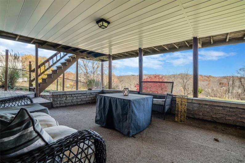 A versatile covered patio space ideal for entertaining or relaxing. Enjoy the serene views and shade, rain or shine, with direct access to the expansive backyard.