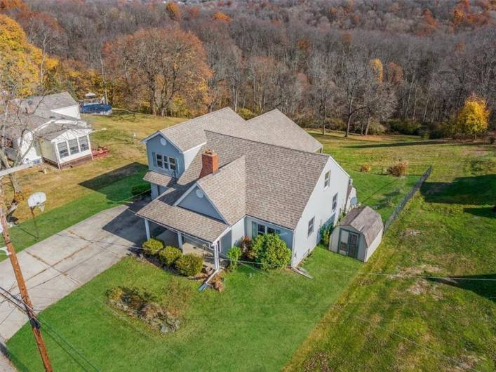 This aerial shot captures the full expanse of the property, highlighting the home, the lush yard, and scenic surroundings. The layout provides both space and privacy.