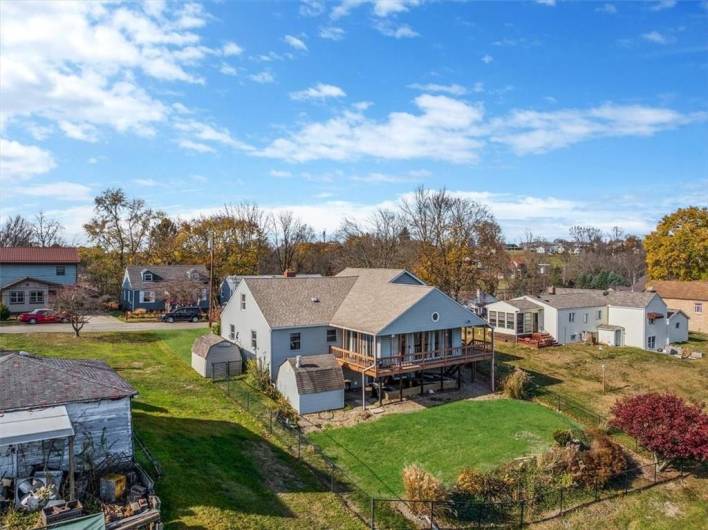 This side angle of the property includes both the fenced backyard and side structures, such as a small shed. It highlights the layout and flow from the main house to the outdoor spaces, giving potential buyers a comprehensive view of the property’s external amenities.